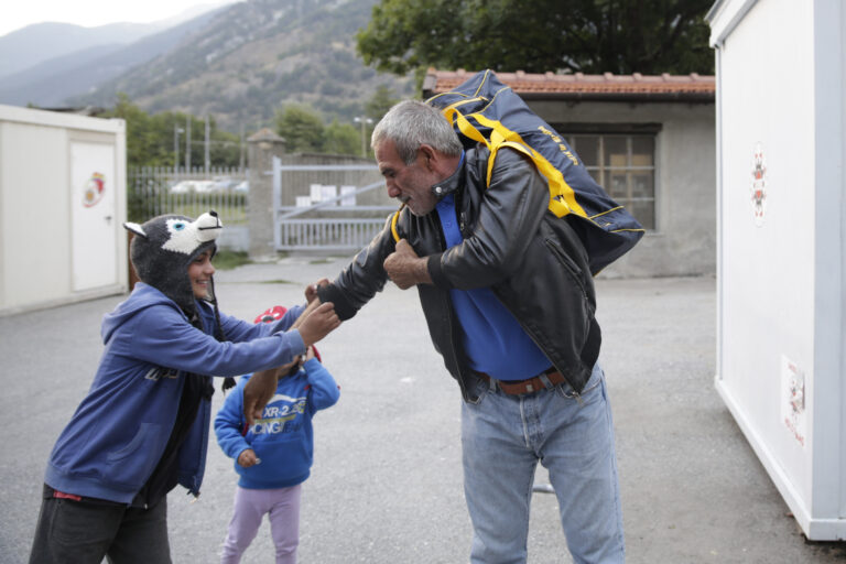 Un nieto ayuda a su abuelo a colocarse la mochila en el refugio ‘Fraternitá Massi’ (Oulx, Italia). Esa misma noche intentaron cruzar la frontera a través de las altas montañas de los Alpes con el objetivo de llegar al siguiente refugio en Briançon (Francia). Eduardo Oyana